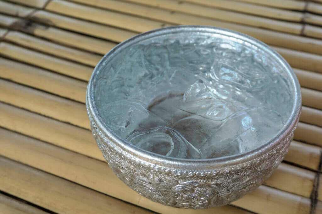 Drinking water and ice cube in metal bowl, Thai traditional container