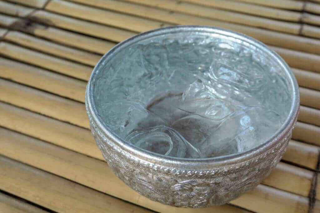 Drinking water and ice cube in metal bowl, Thai traditional container