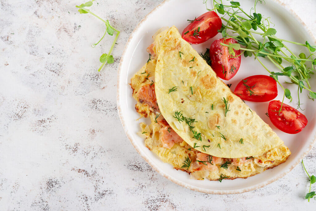 Healthy breakfast. Quesadilla with omelette, salmon and sliced tomatoes. Keto, ketogenic lunch. Top view