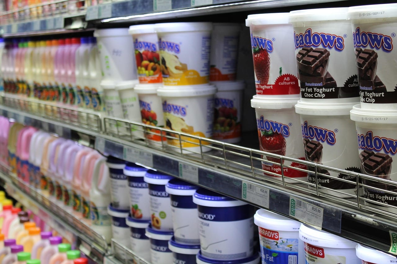 Tubs of yogurt displayed on store shelf