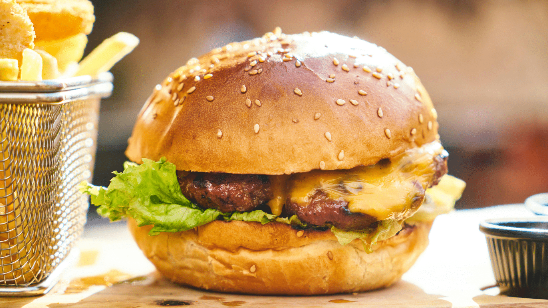 Close-up of a juicy hamburger with lettuce, tomato, and cheese on a wooden board