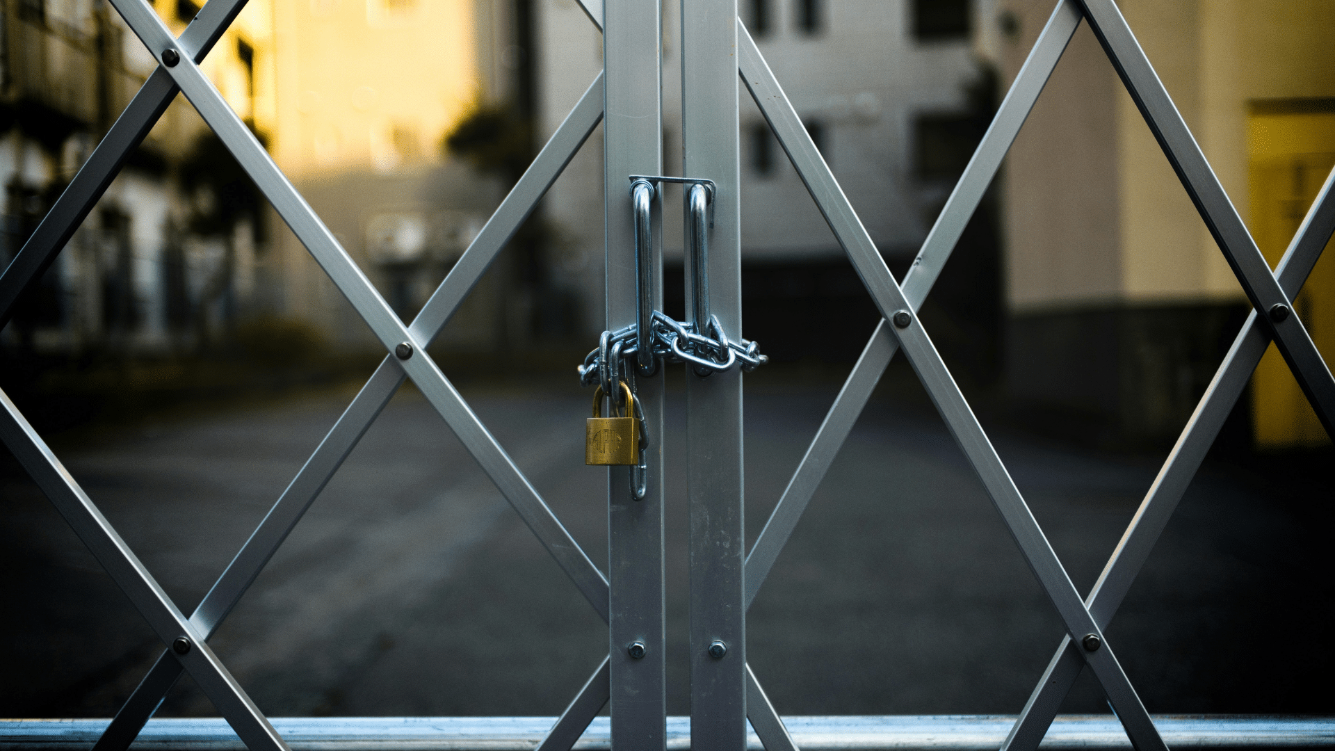 Heavy steel gate closed with industrial padlock