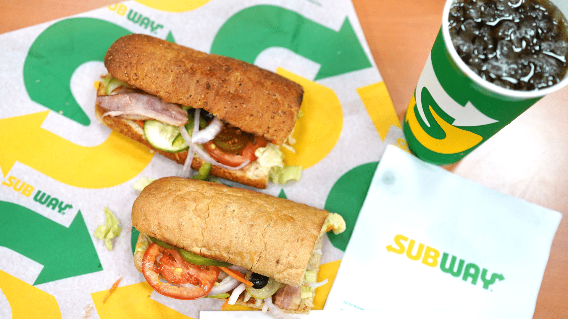 Fresh Subway sandwiches on a tray with various toppings and sauces