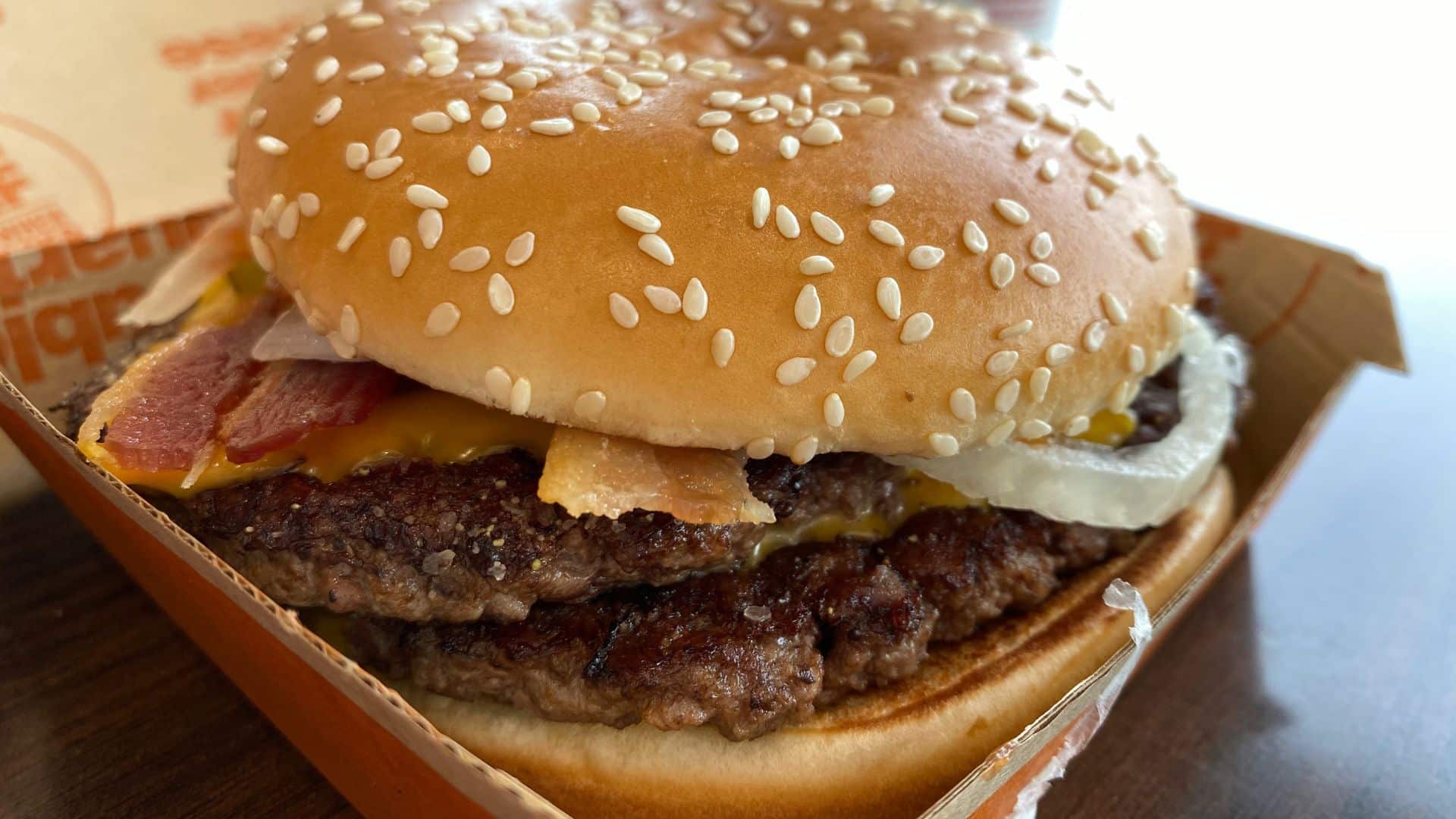 Burger on a wooden table ready to season at home
