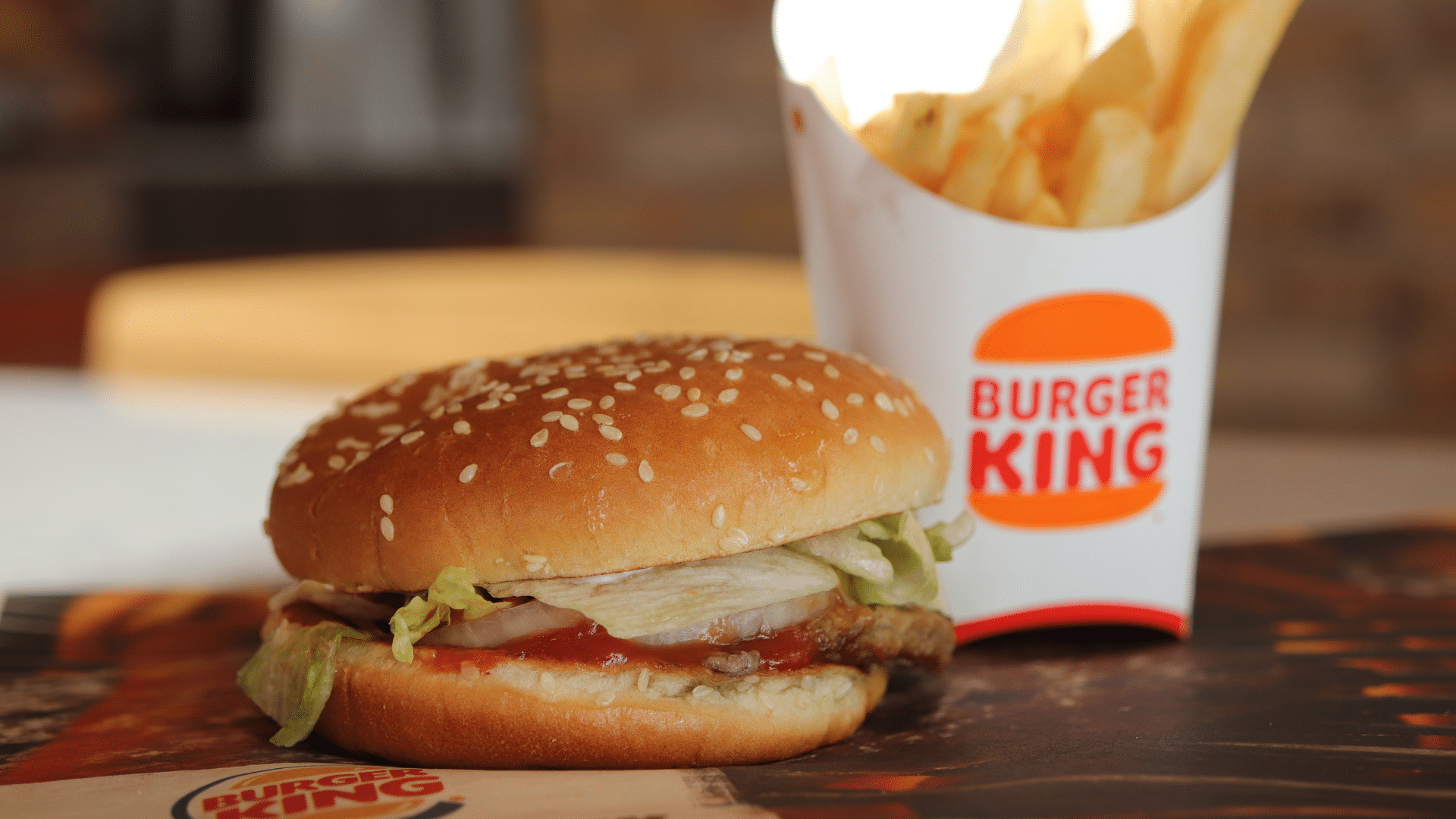 Burger King Whopper Jr. in wrapper with fries and drink