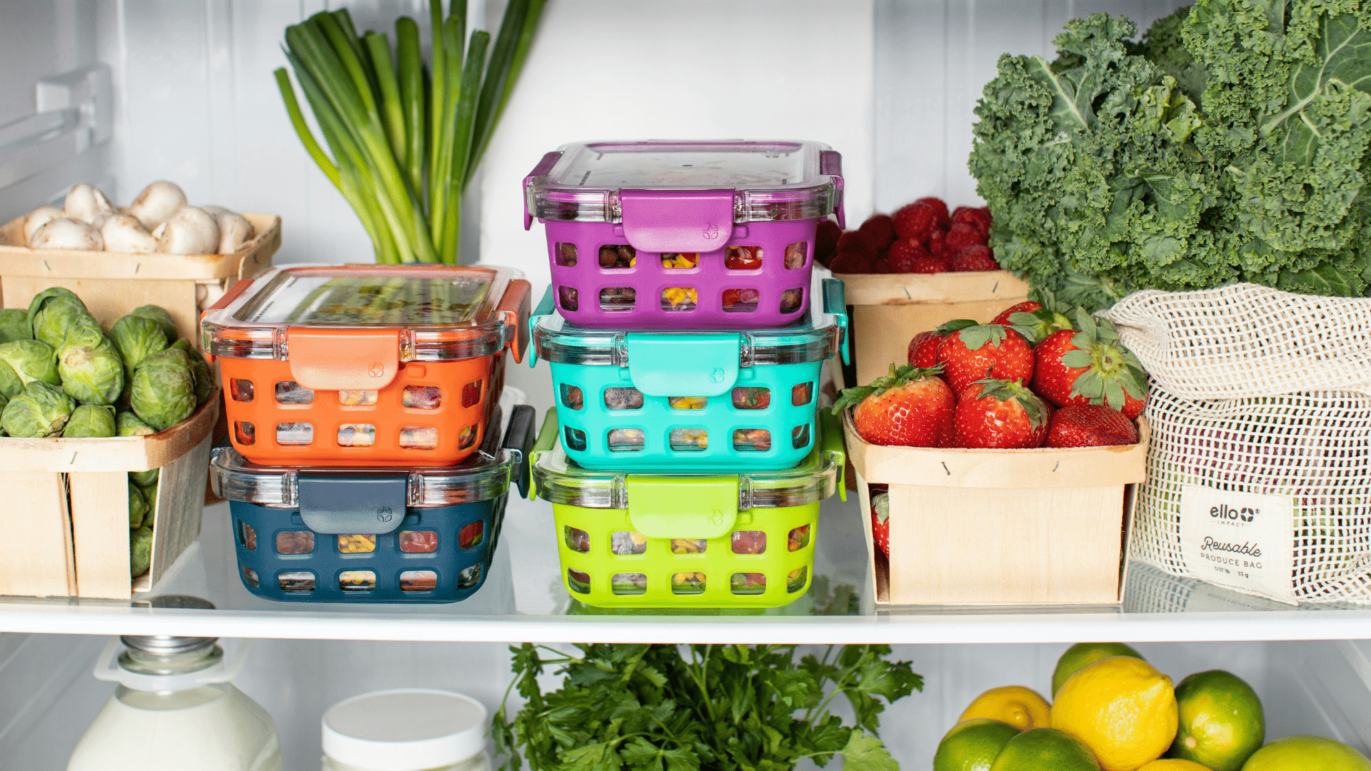 Organized fridge shelves with colorful green and pink plastic containers