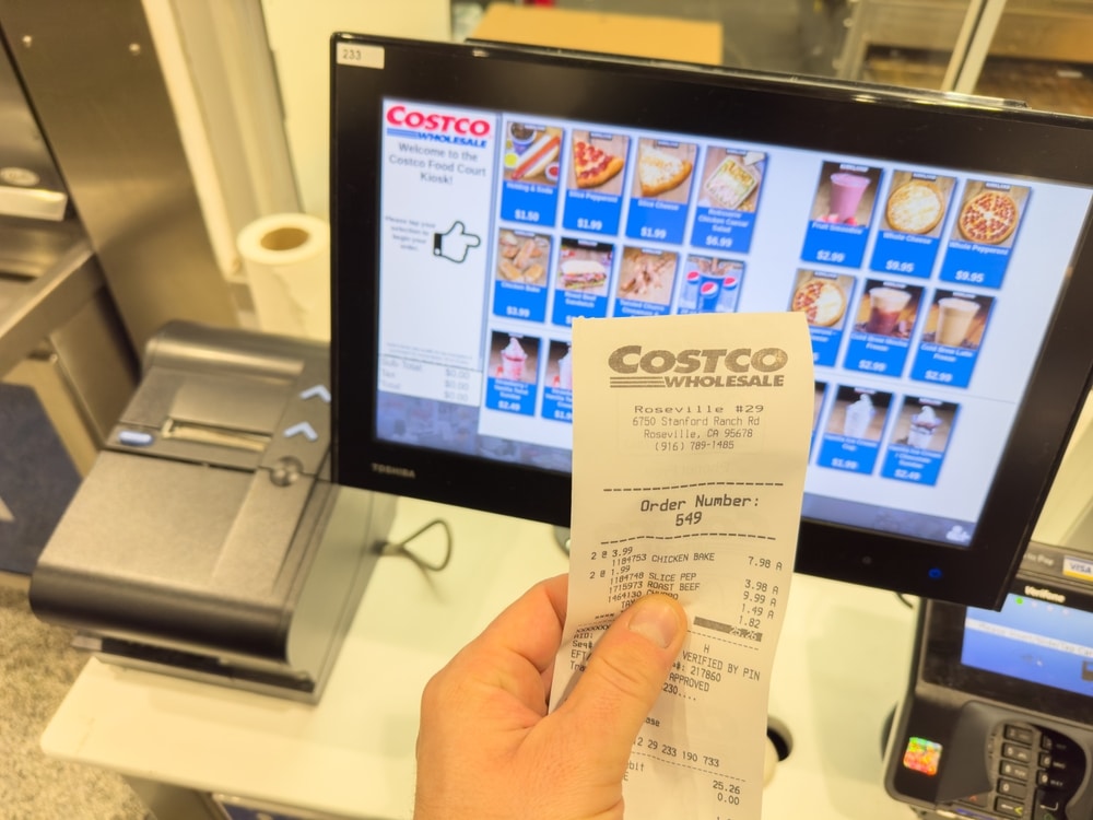 RoseVille, CA - Nov 30, 2023: Holding a receipt from a Food Court next to self check out register, inside Costco warehouse.