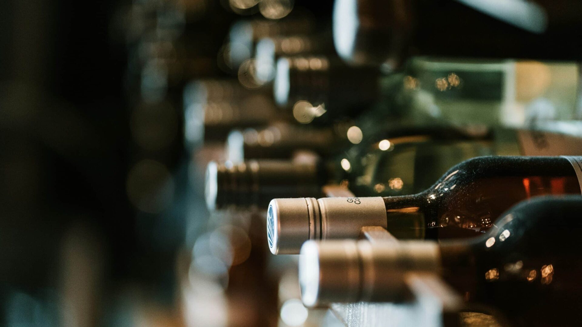 Assorted alcohol bottles displayed on a shelf, shown in selective focus