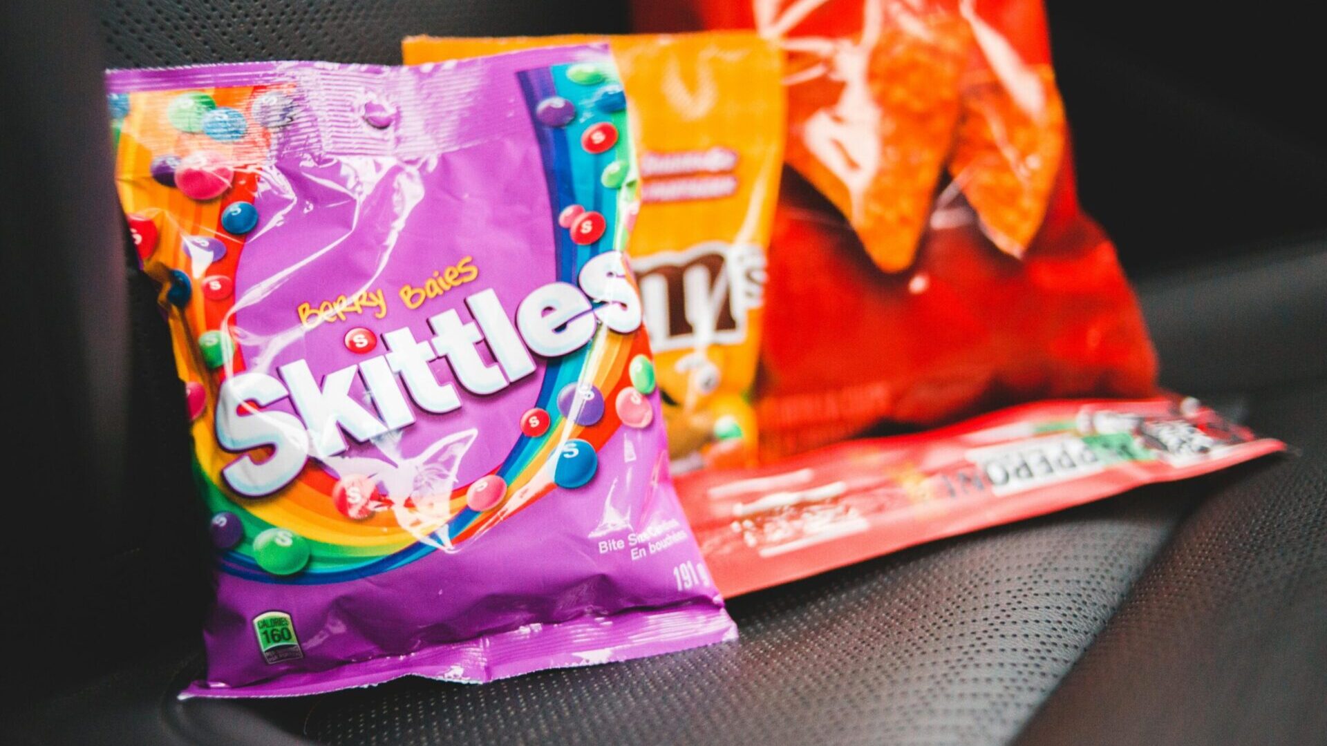 Assortment of various sweets and candies placed on a car seat