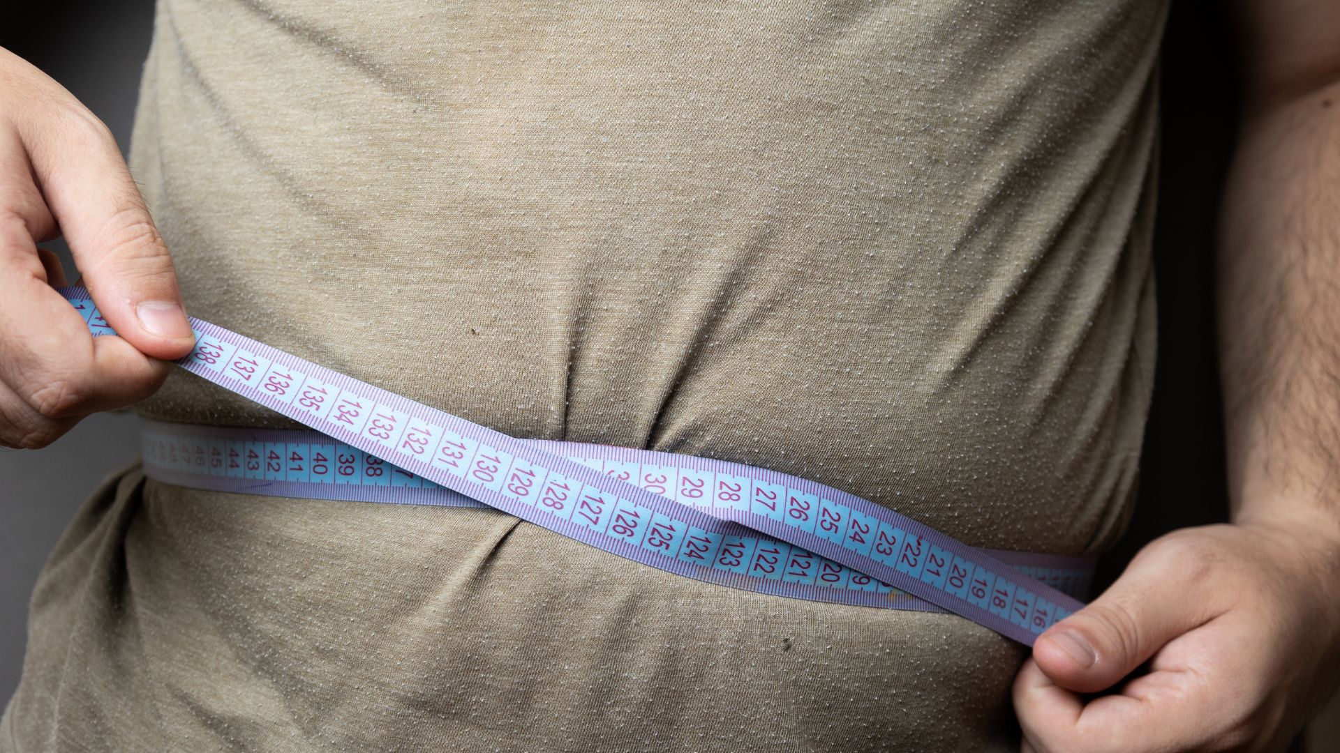 A man with a measuring tape around his waste