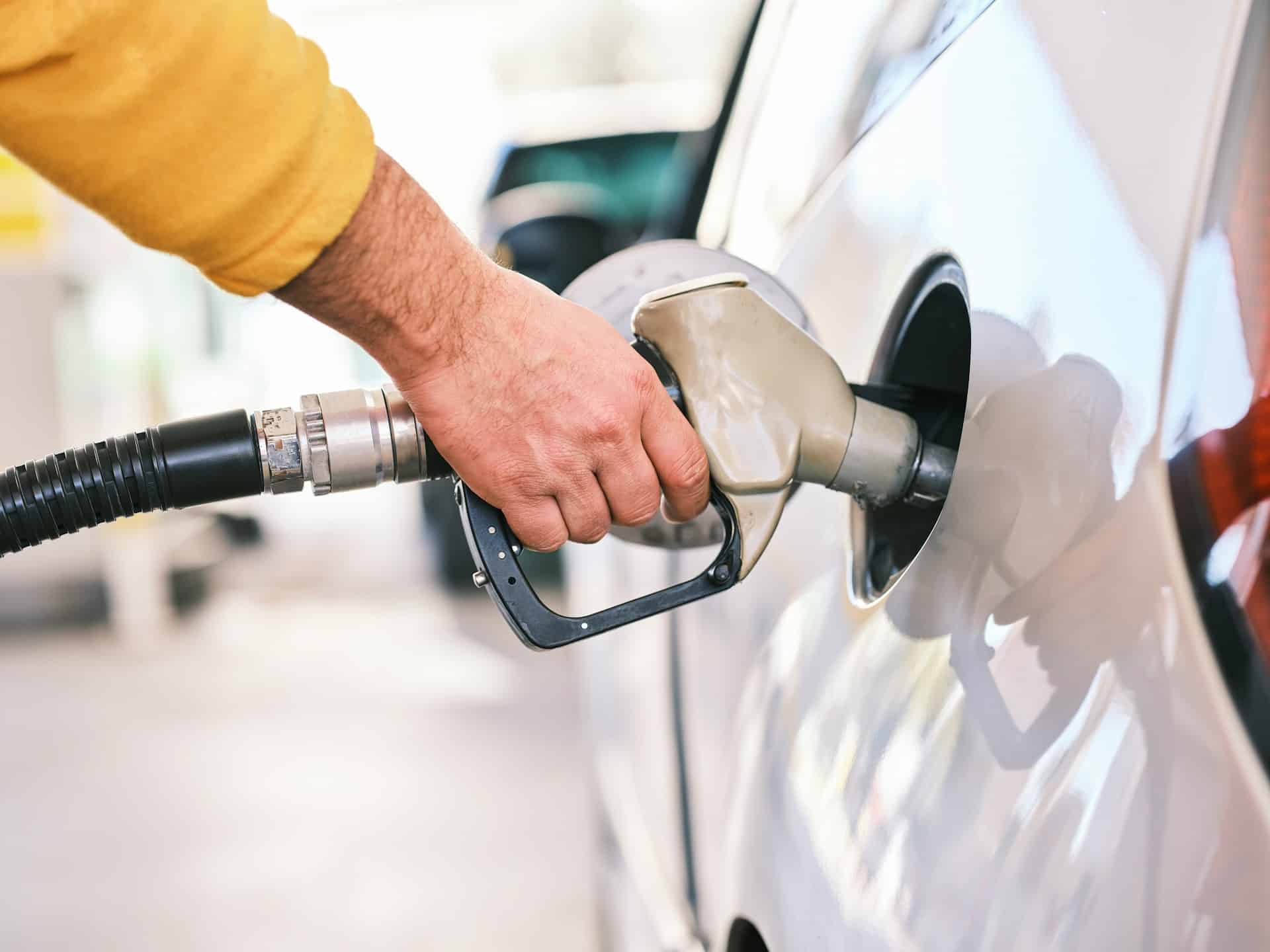 Closeup of a man's hand while pumping gasoline fuel in car at gas station