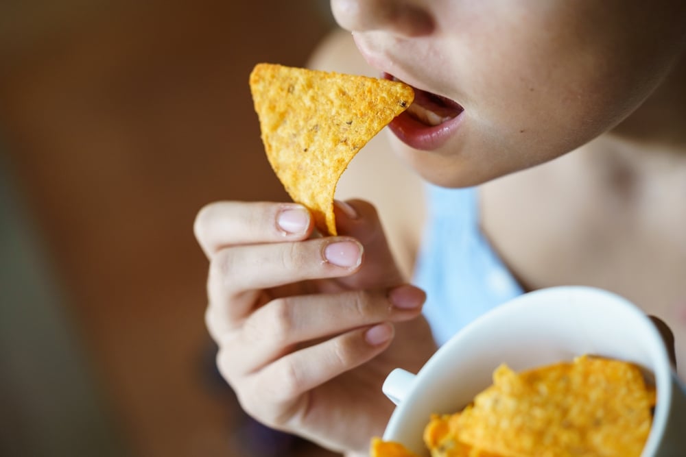 A woman eating Dorito chips