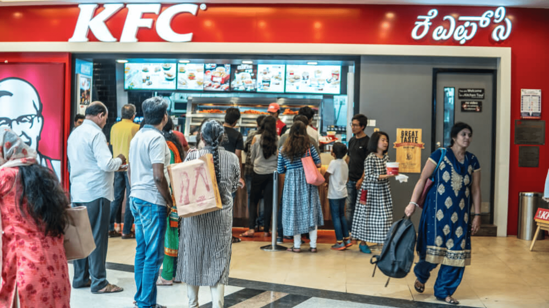 People lining up at a KFC counter inside a mall