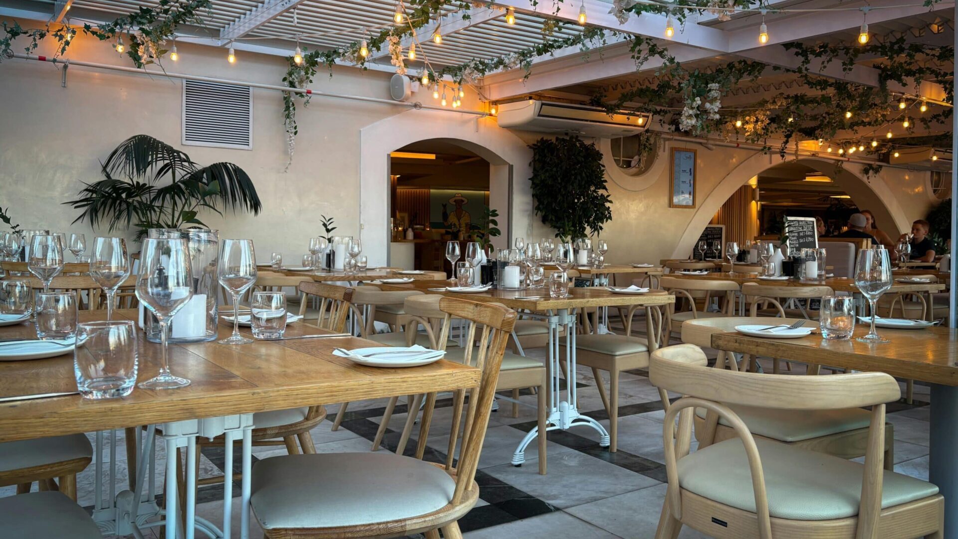 Charming indoor restaurant setting with elegant decor, warm lighting, and neatly set tables ready for guests.