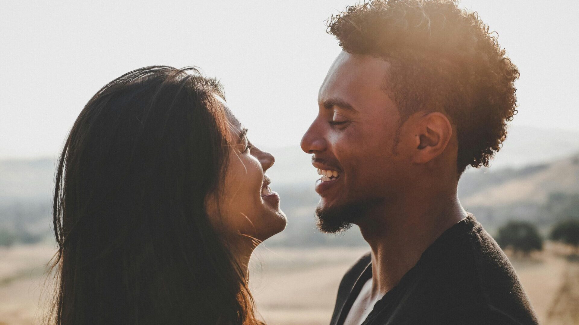 Man and woman standing face to face in an intimate moment.