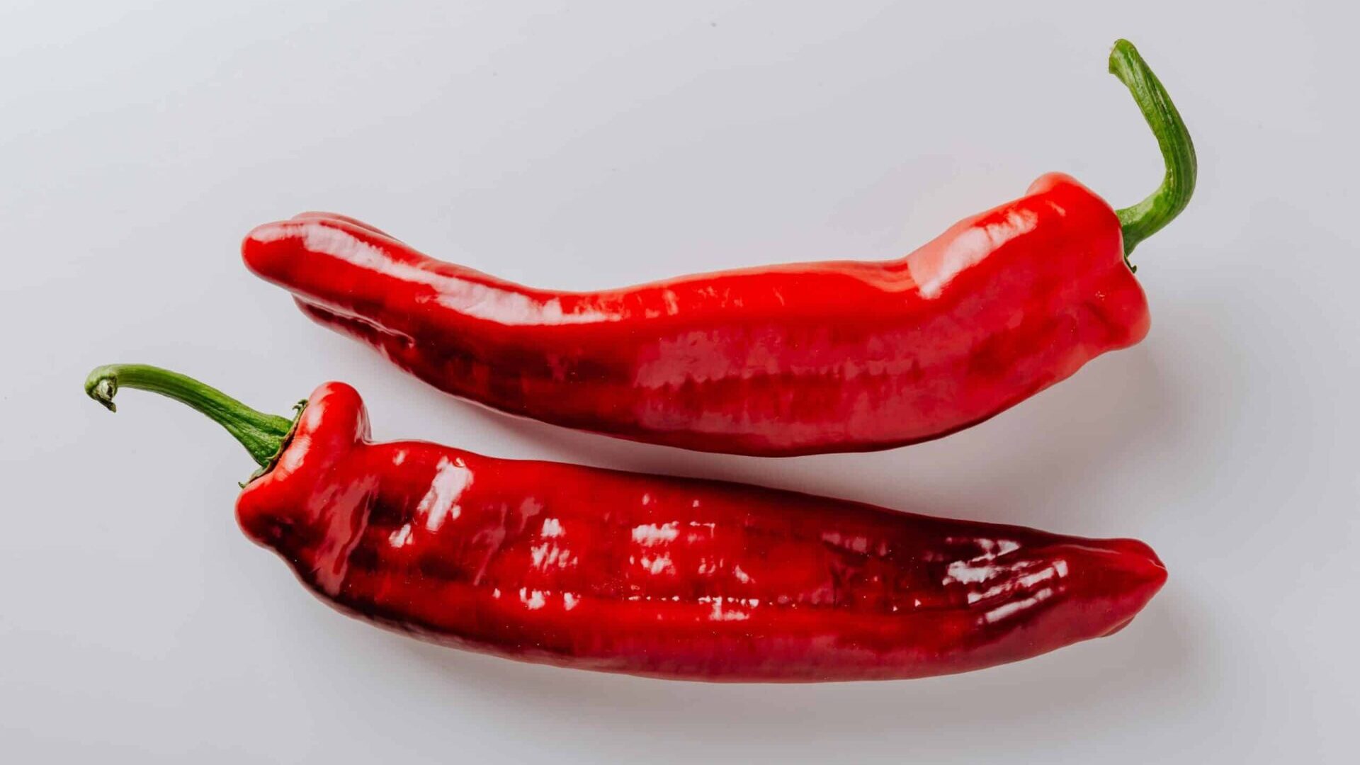 Single red chili pepper on a white background.