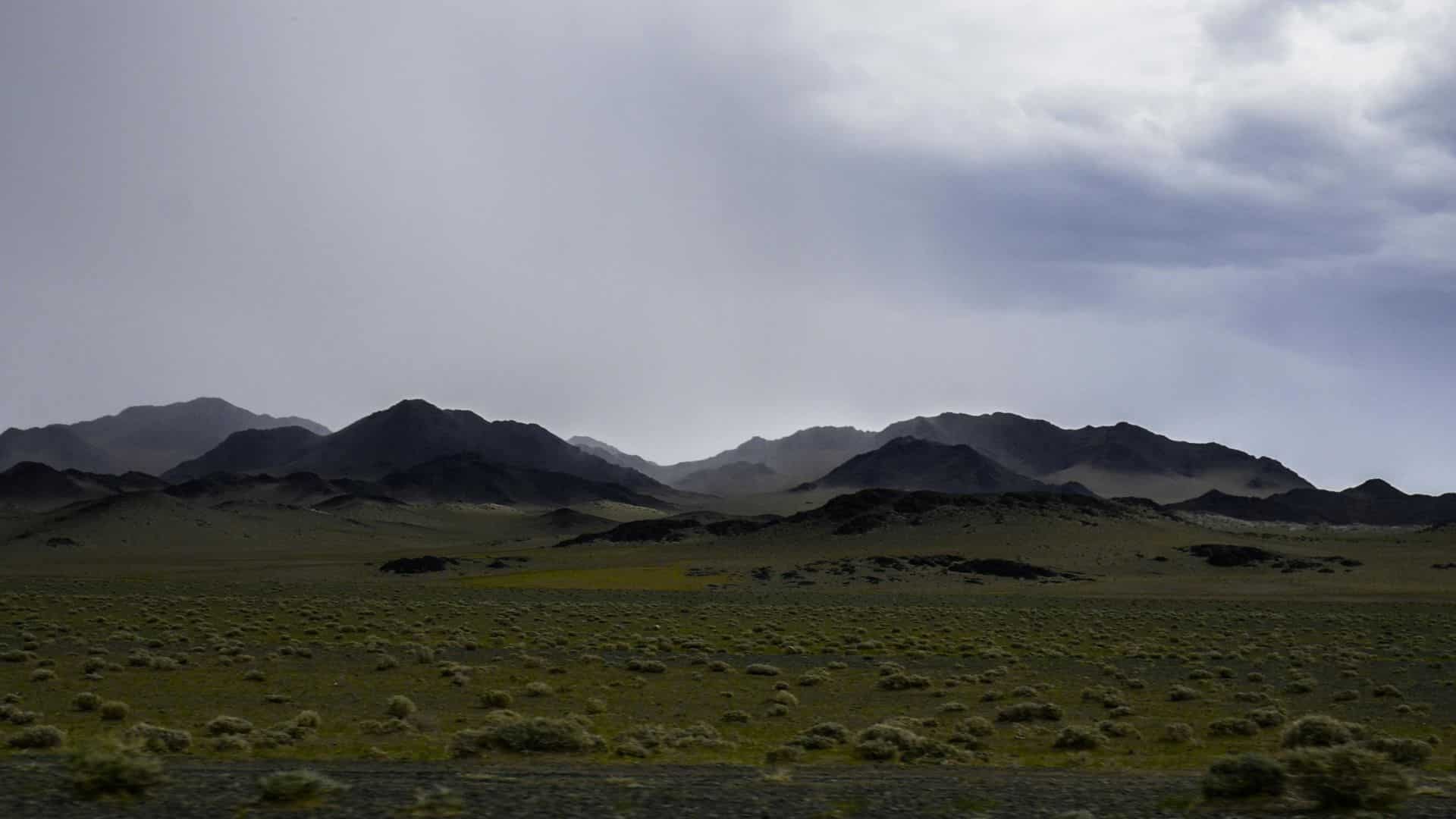 Green valley bordered by mountains and open fields