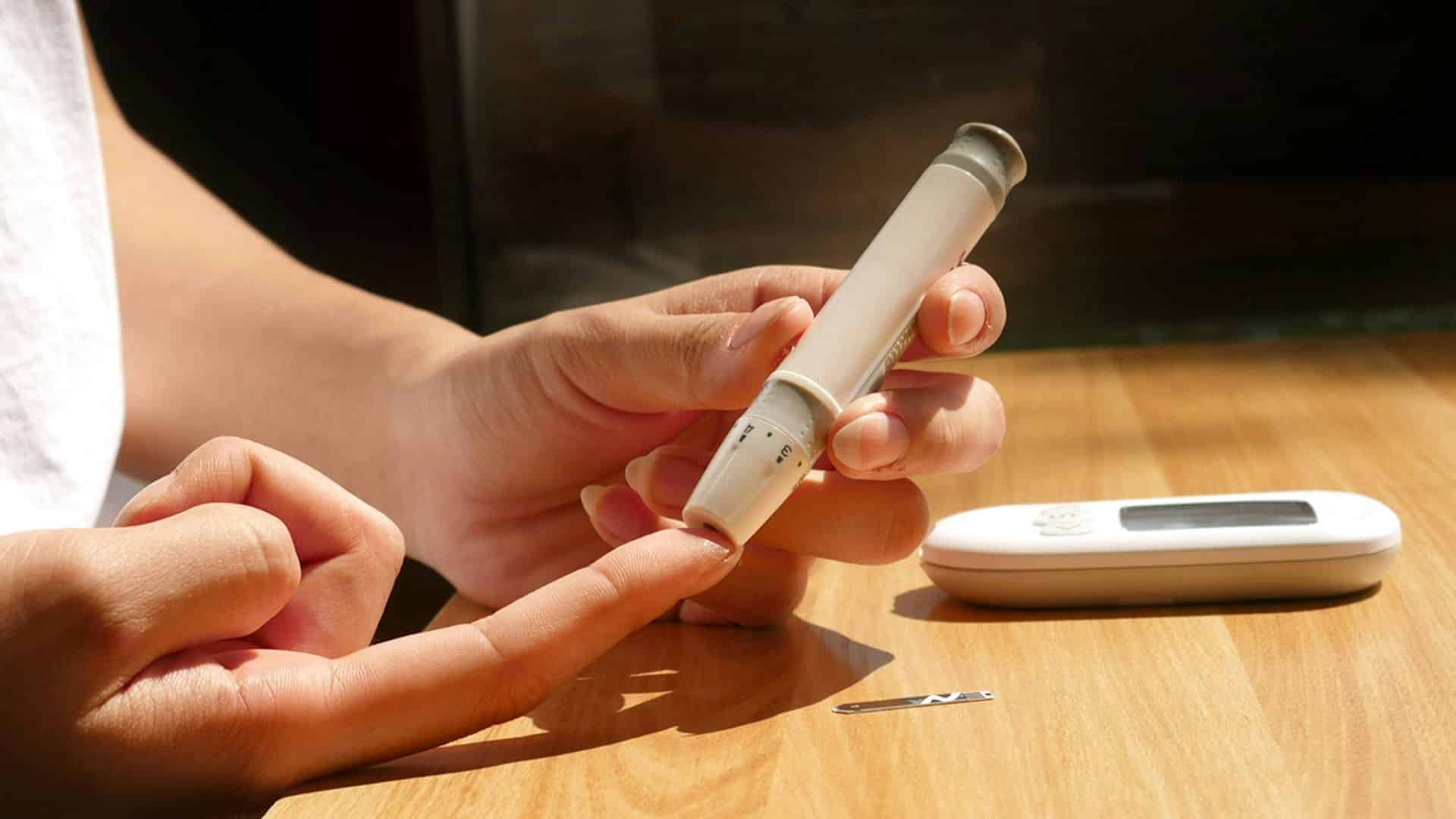 Person seated at a table using a mobile phone near food items