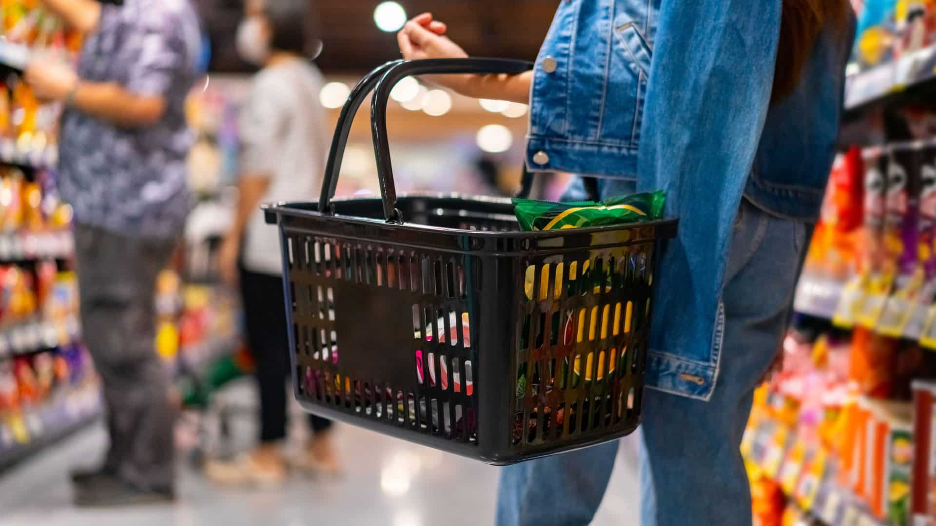People holding shopping basket inside a grocery store