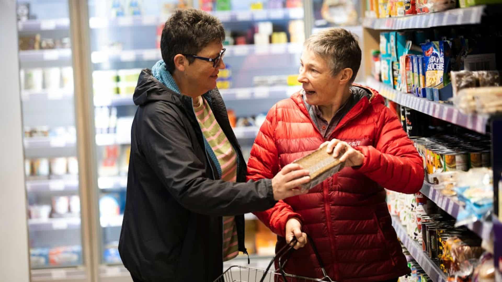 Elderly women talking about a product in a supermarket