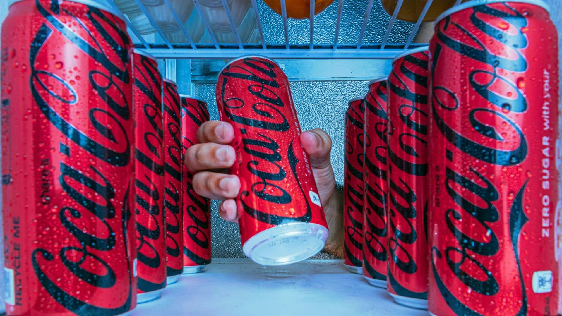 Hand grabbing Coke Zero from a fridge
