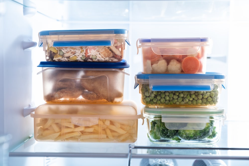 Stack of glass food containers inside a refrigerator