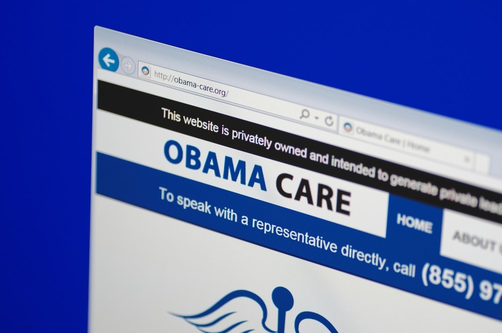 A computer screen shows details of Obama Care main website page