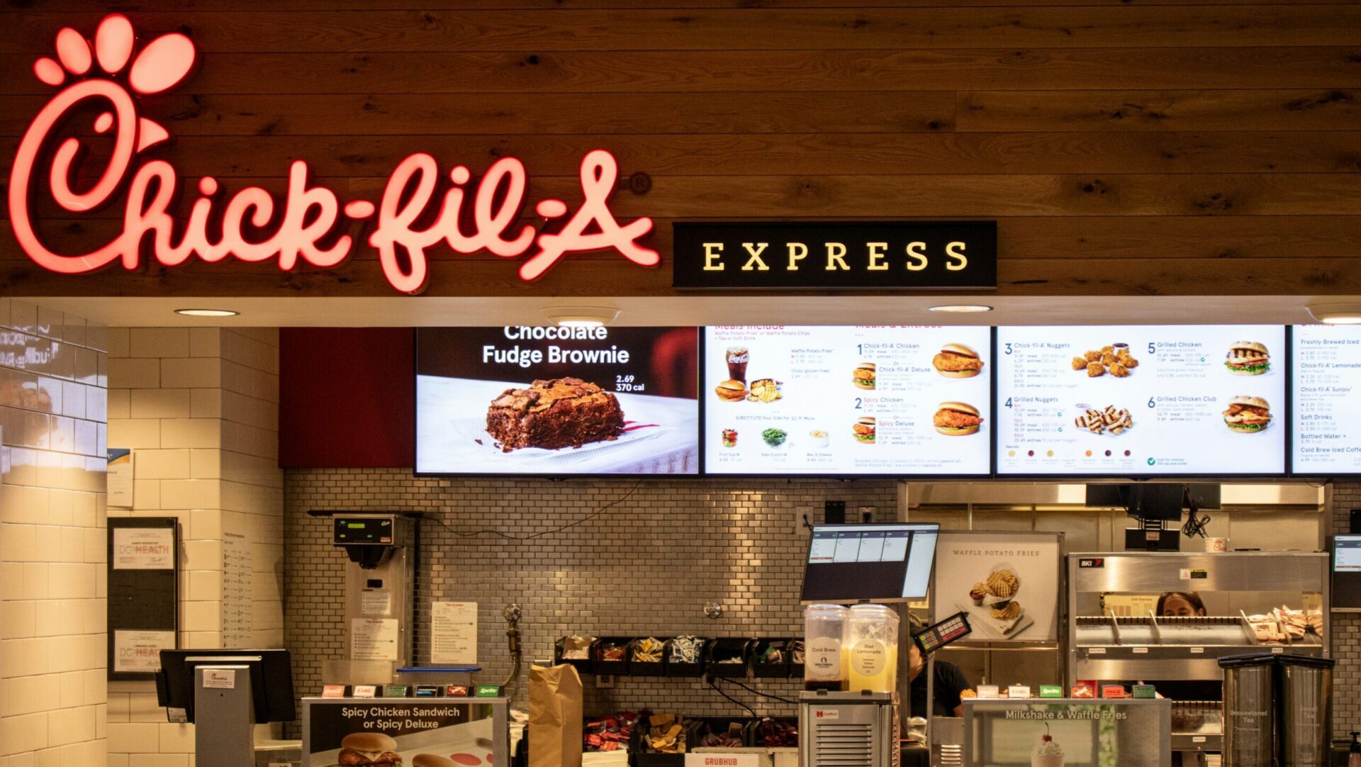 Interior of a fast food restaurant with a large menu board displaying menu options above the counter.