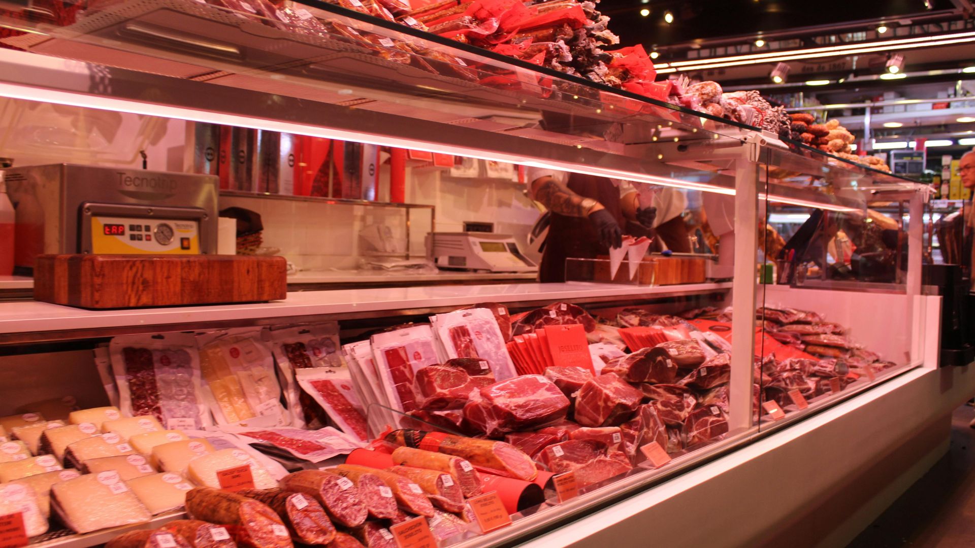 Refrigerated meat section inside a supermarket with packaged cuts on display