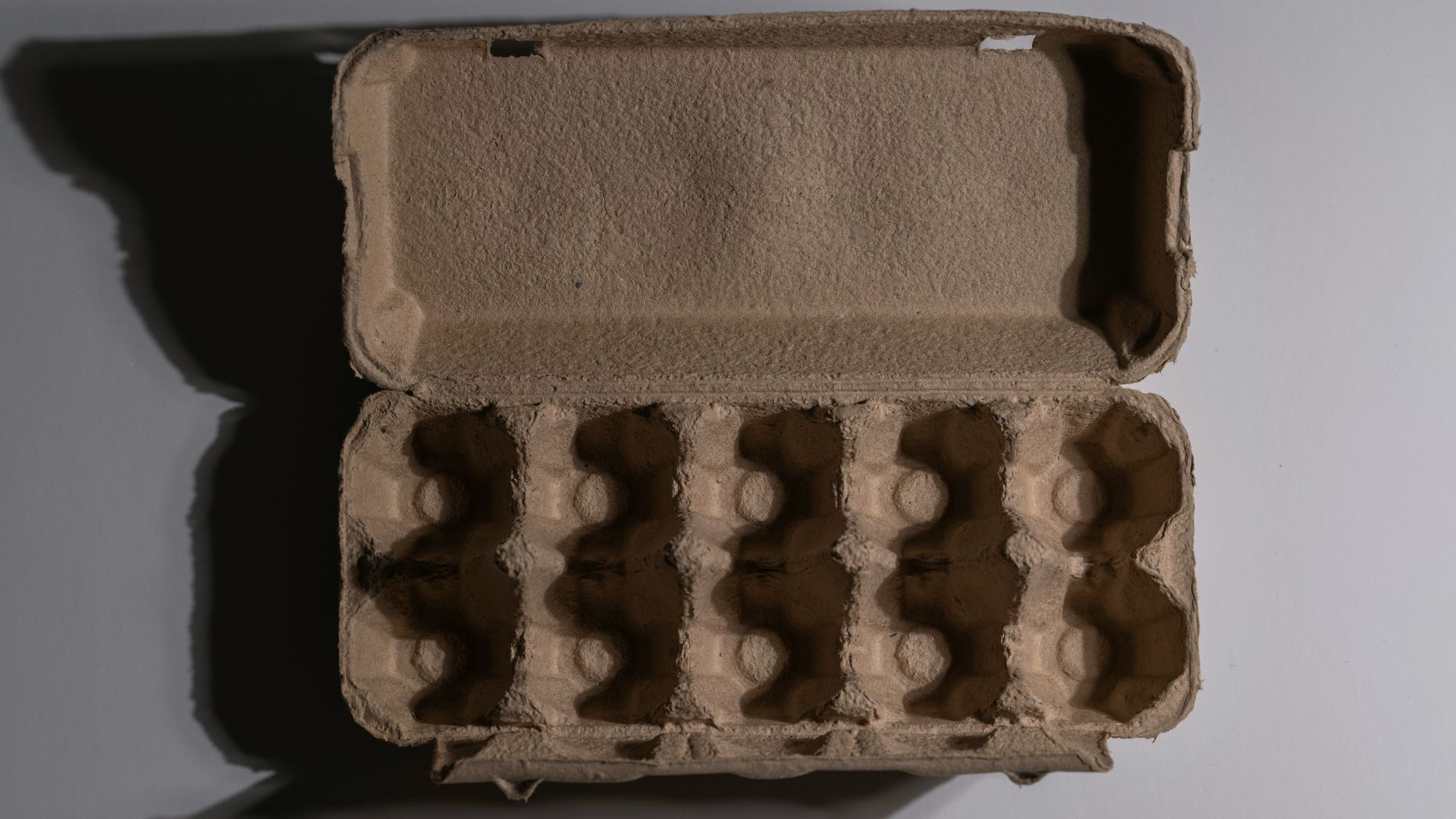 Empty cardboard egg carton sitting on a table.