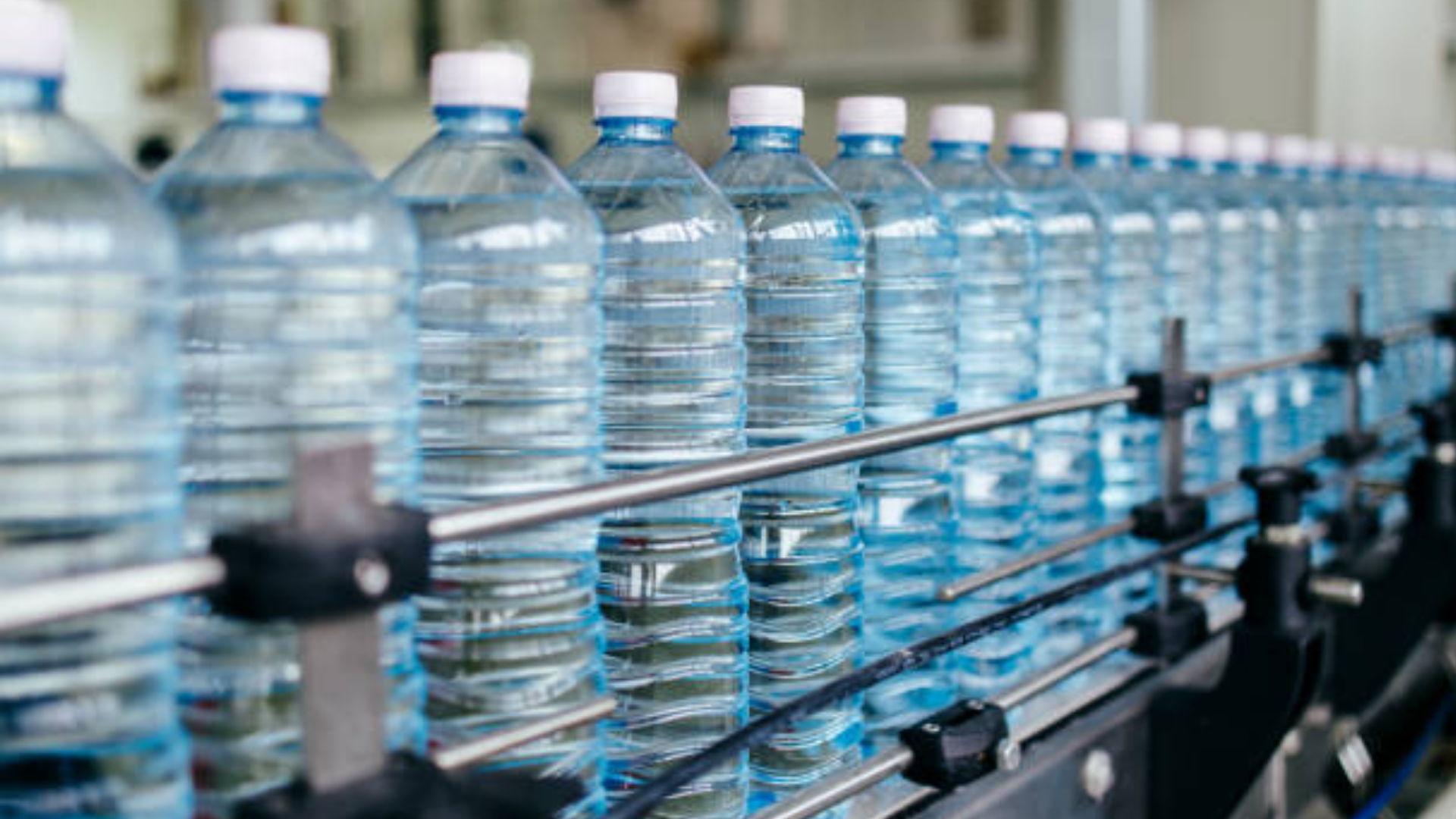 Plastic water bottles moving along a bottling plant production line.