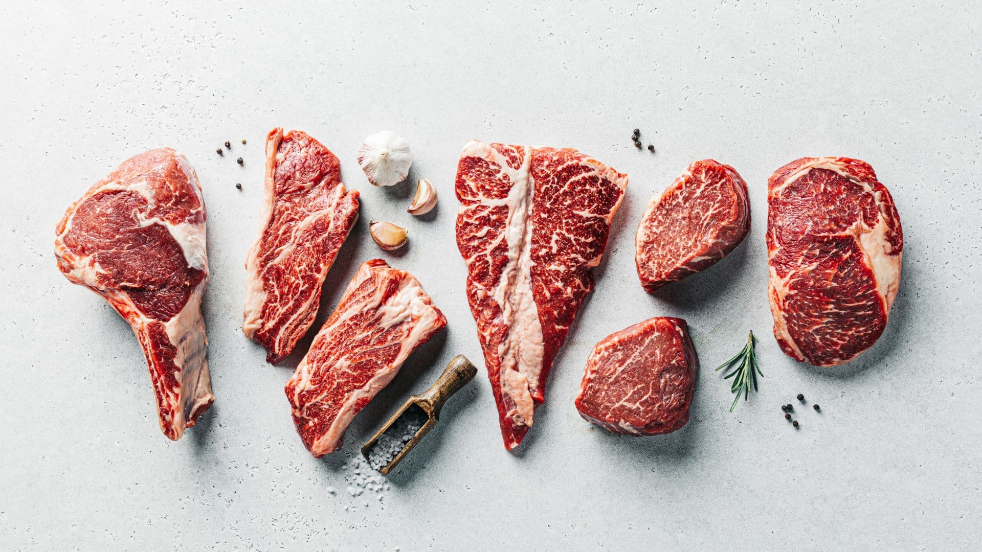Assorted raw cuts of red meat arranged on a table