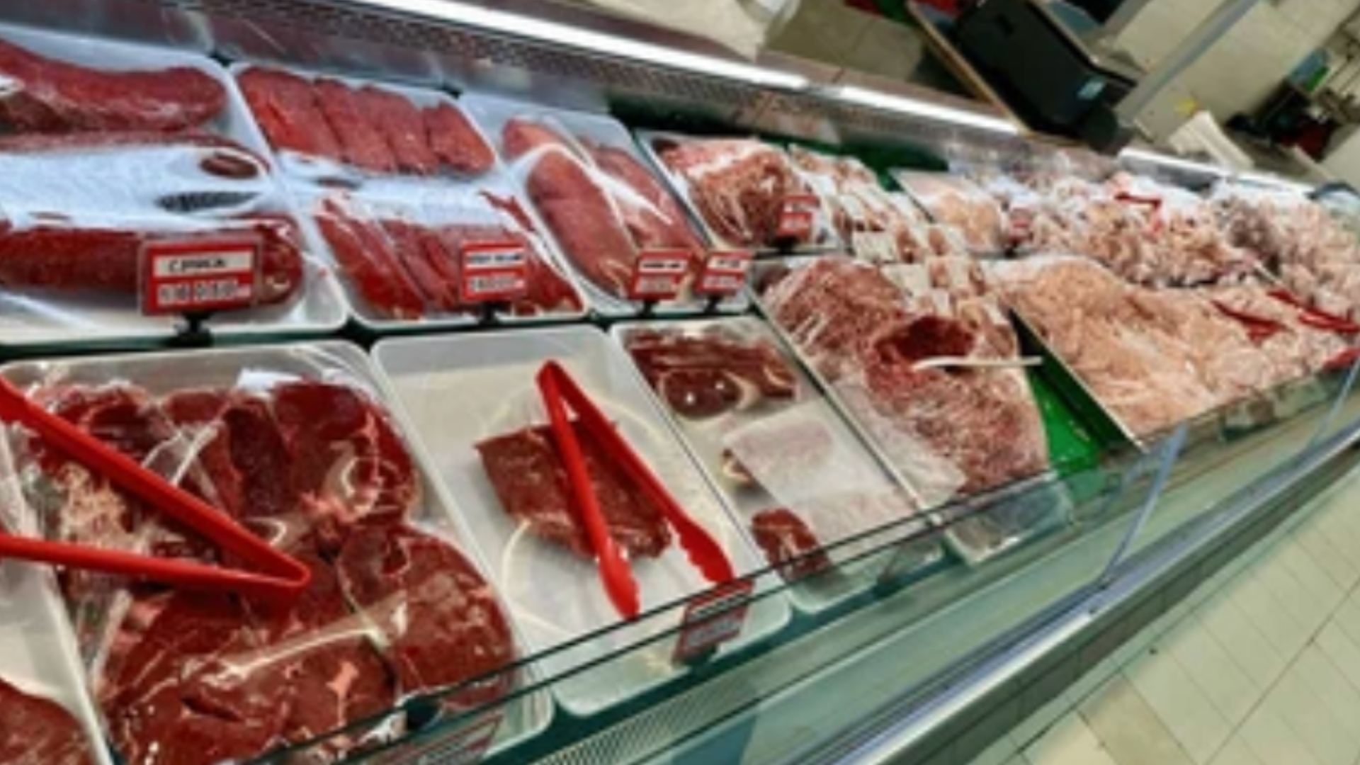 Packaged raw meat on display in a grocery store.