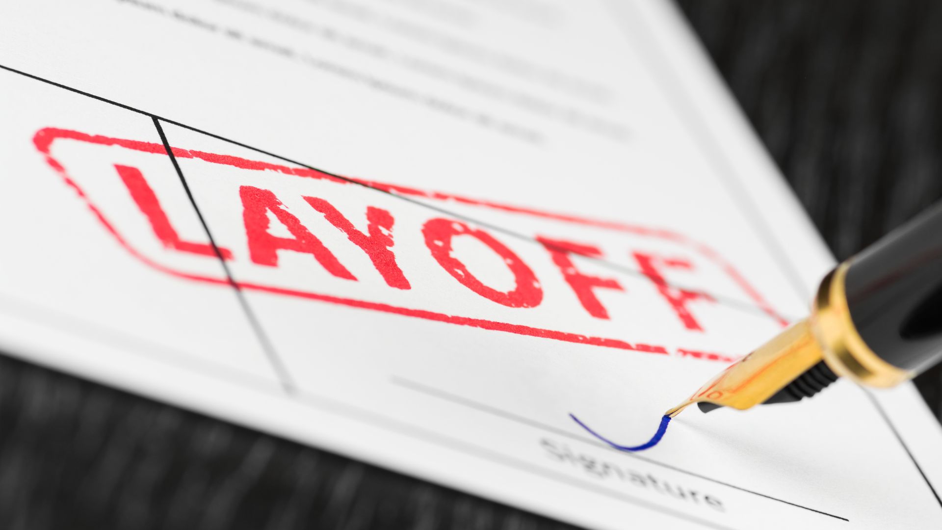 Official document stamped with the word layoff next to a fountain pen