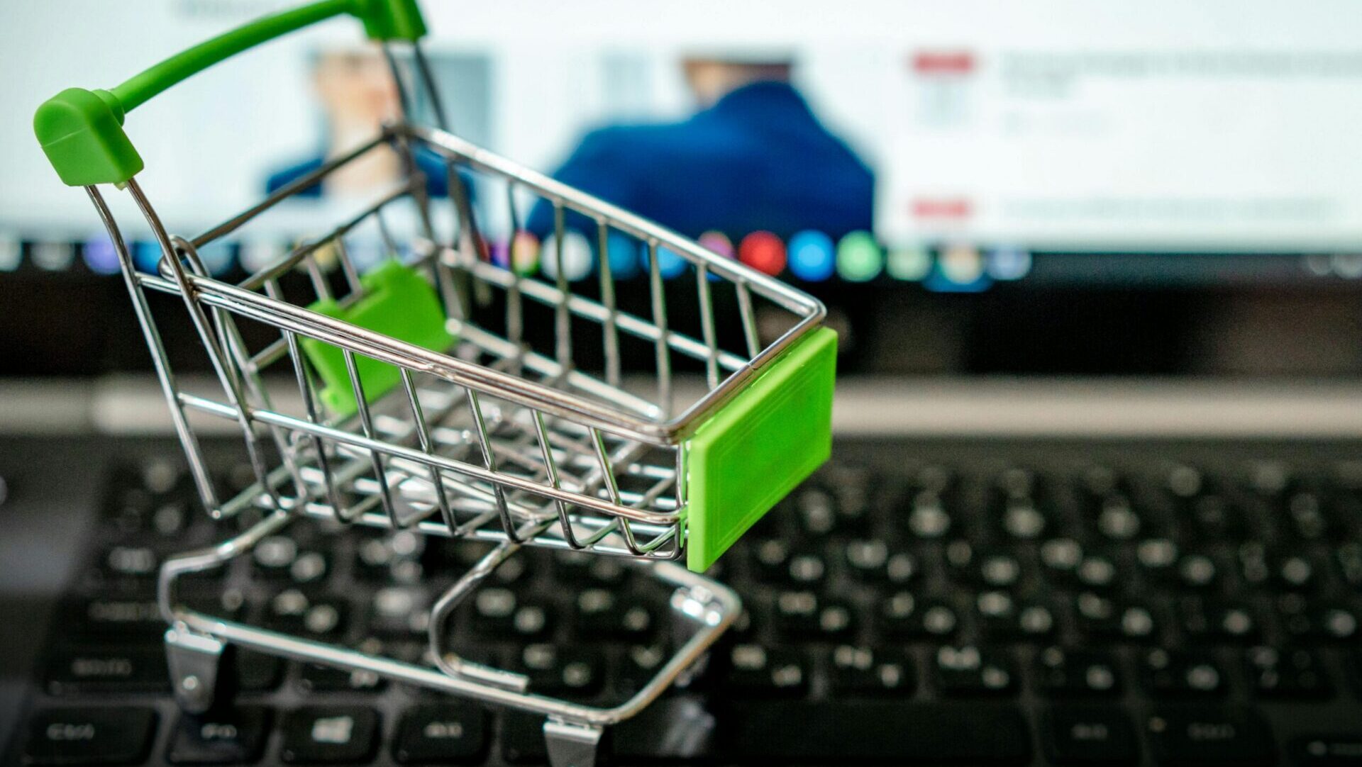 Close-up of a miniature shopping cart on a flat surface.