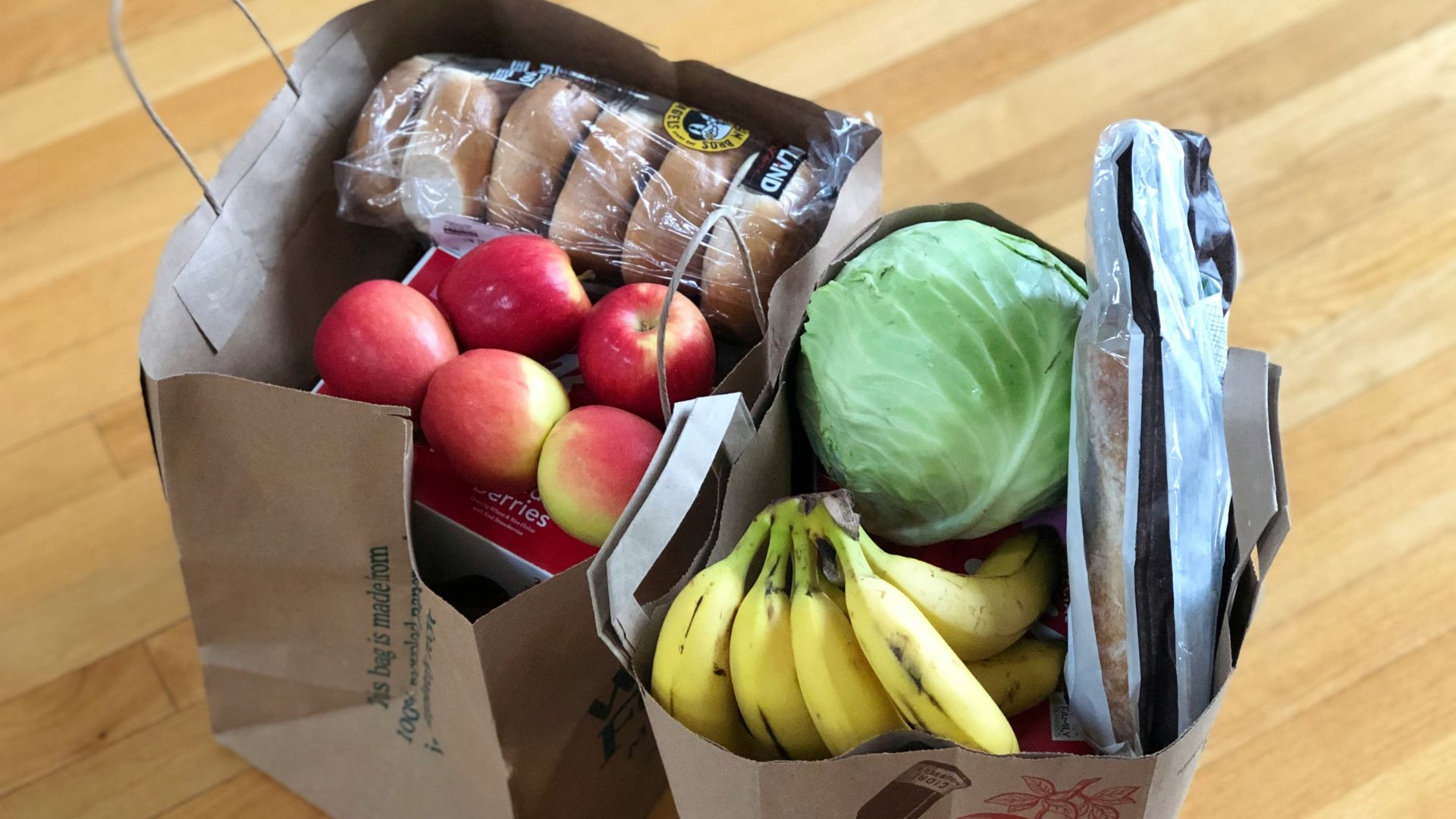 Apples and bananas packed in a cardboard box for food distribution