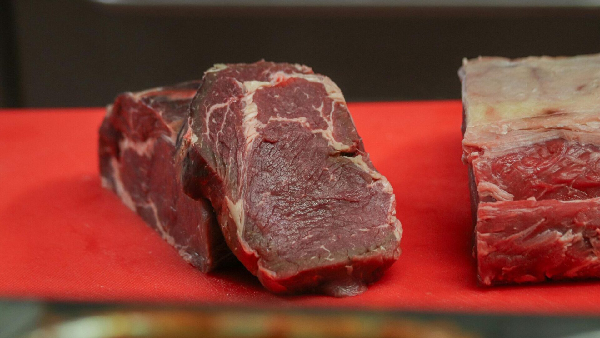 Fresh cuts of beef displayed in a butcher’s showcase.