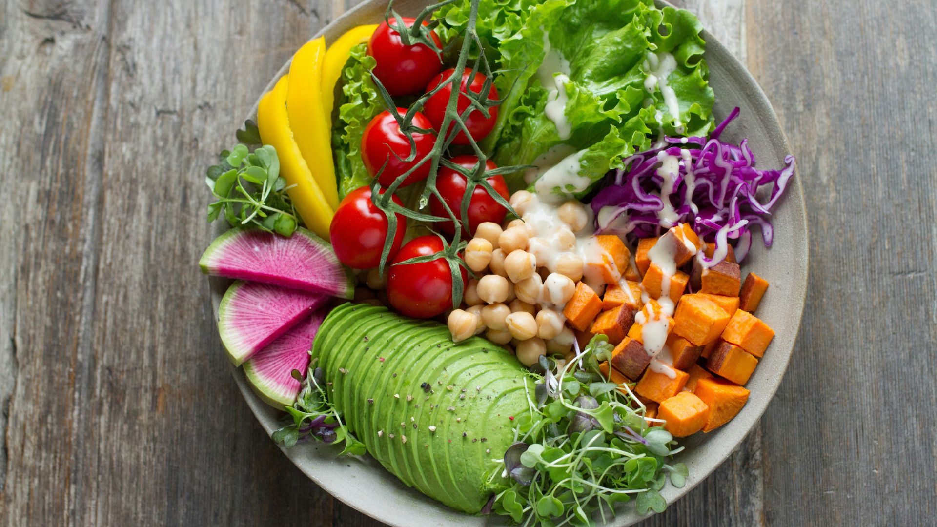 Bowl of vegetable salad with leafy greens and sliced produce