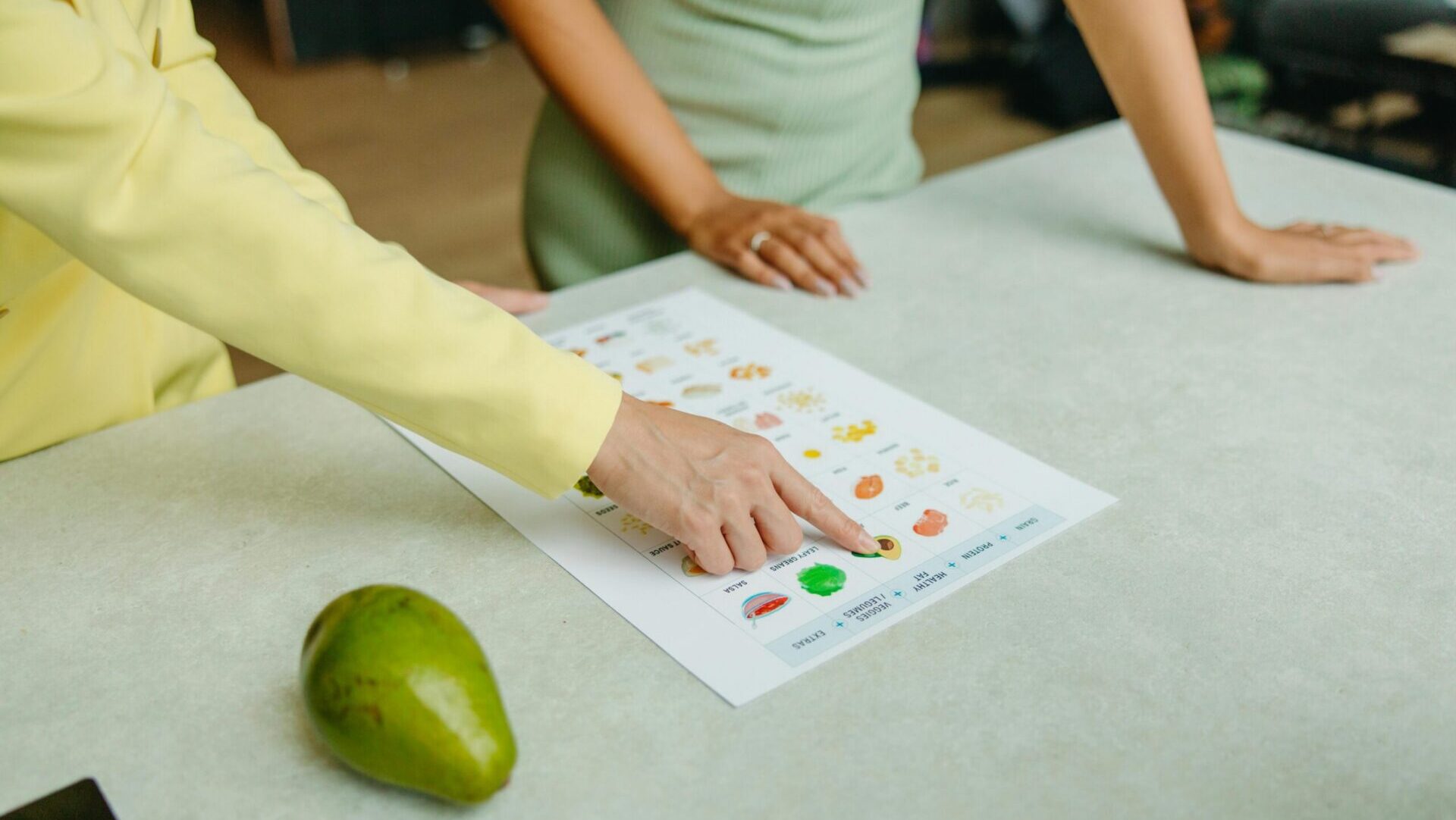 Nutrition professional pointing to a healthy eating chart.