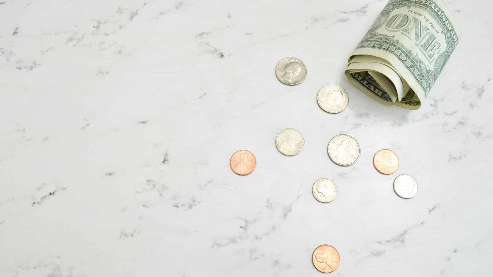 Mixed assortment of banknotes and coins spread on a table