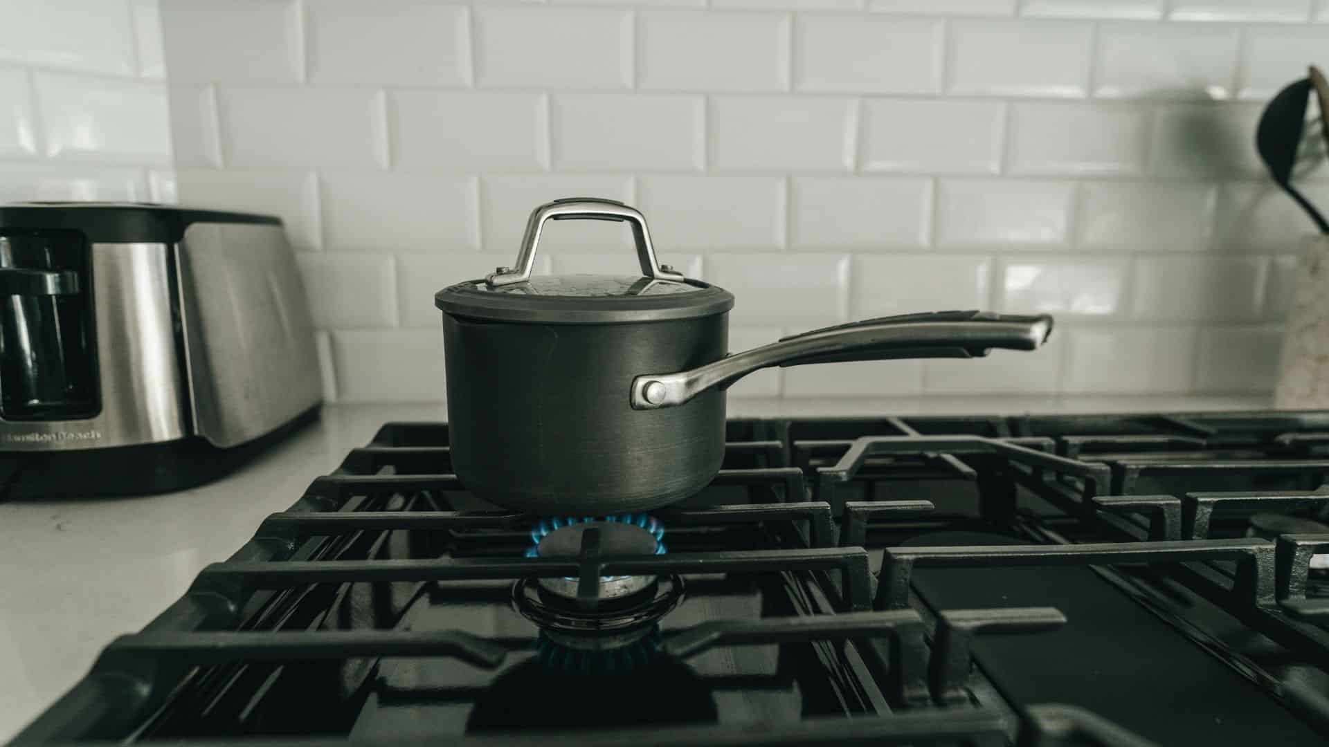 Tea kettle heating on a gas stove burner indoors
