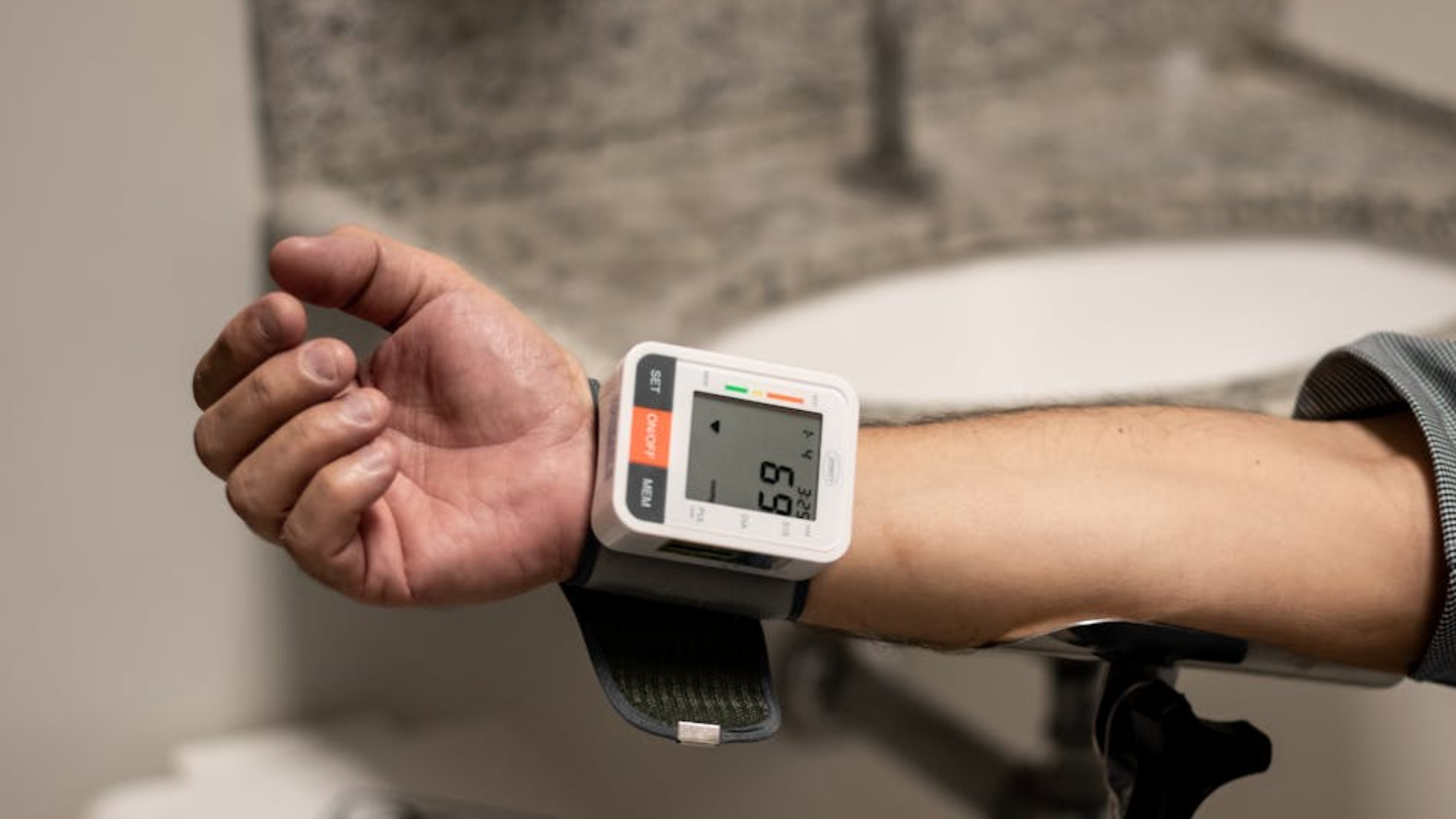 person using at home blood pressure checker