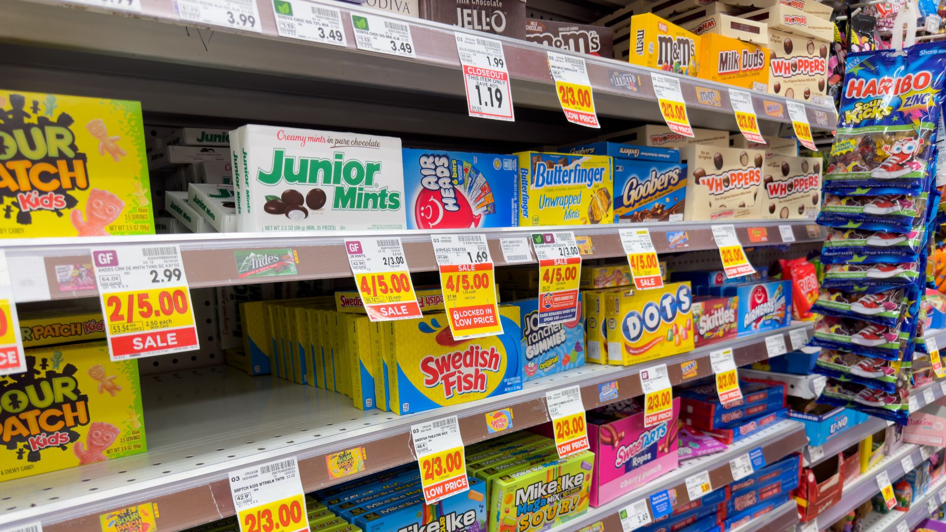A view of several shelves dedicated to brands of boxed candies, on display at a local grocery store