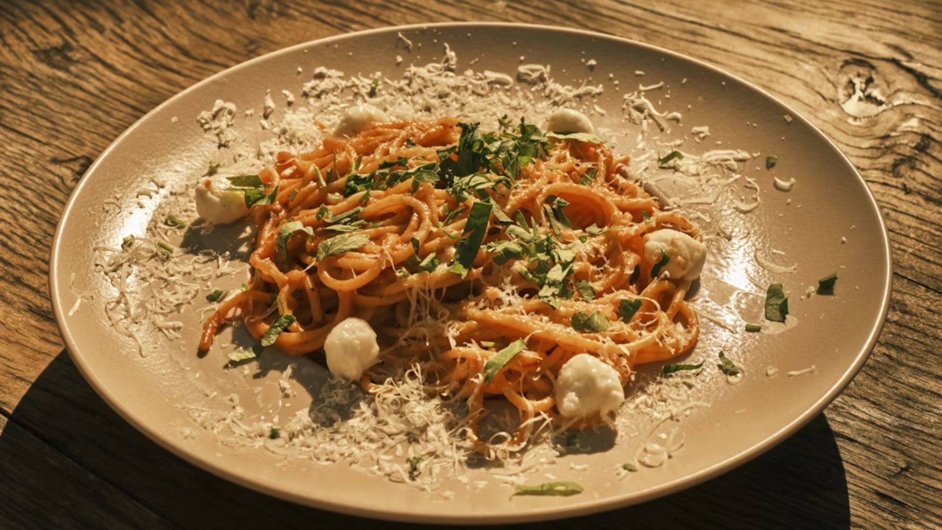 Pasta with red sauce, fresh herbs, and fresh cheese on top