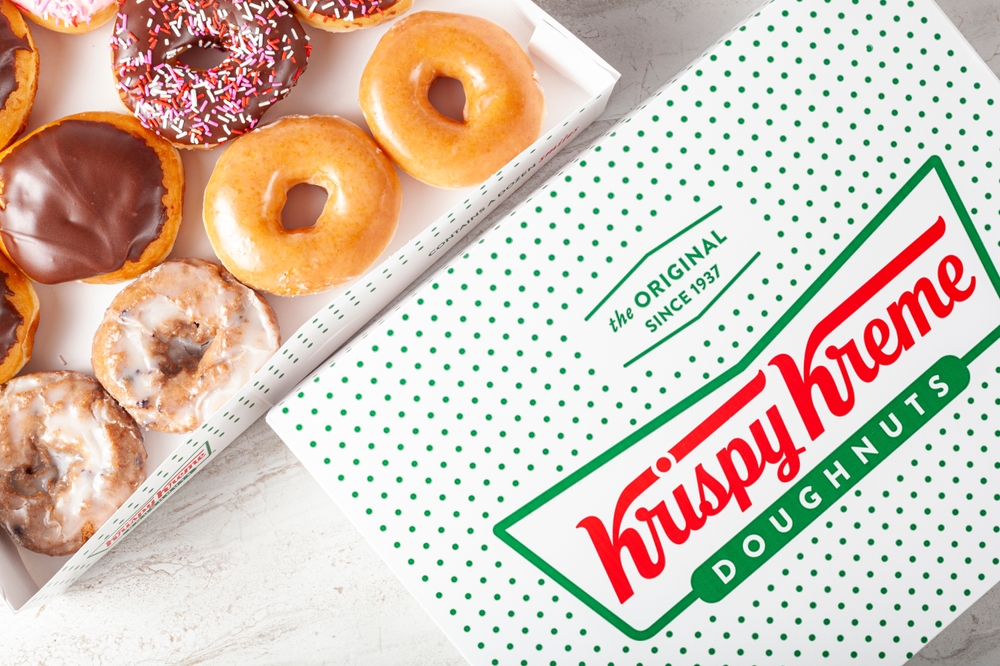 Close-up of assorted Krispy Kreme doughnuts in a branded dozen box.