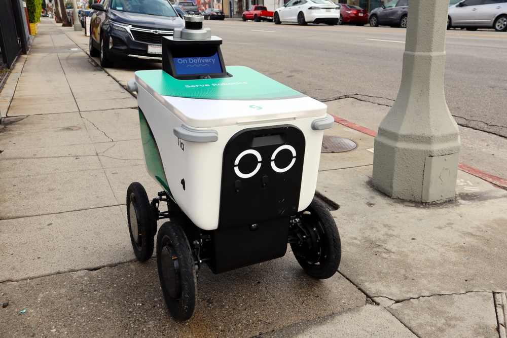 A Serve Robotics delivery robot parked on the side of the street.