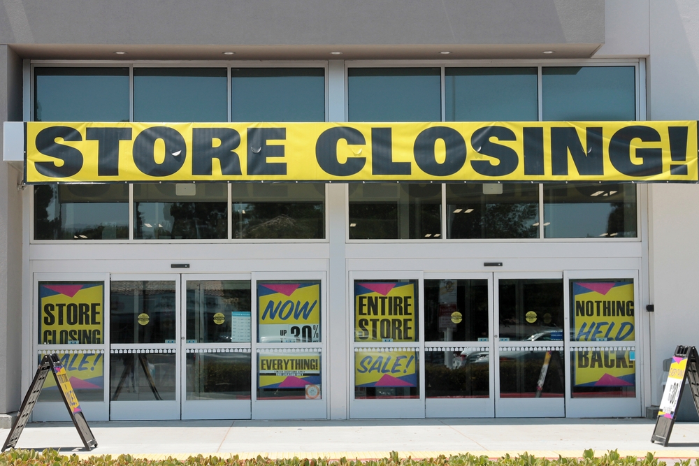 Storefront with large "Store Closing!" banner and sale signs displayed on the entrance doors.