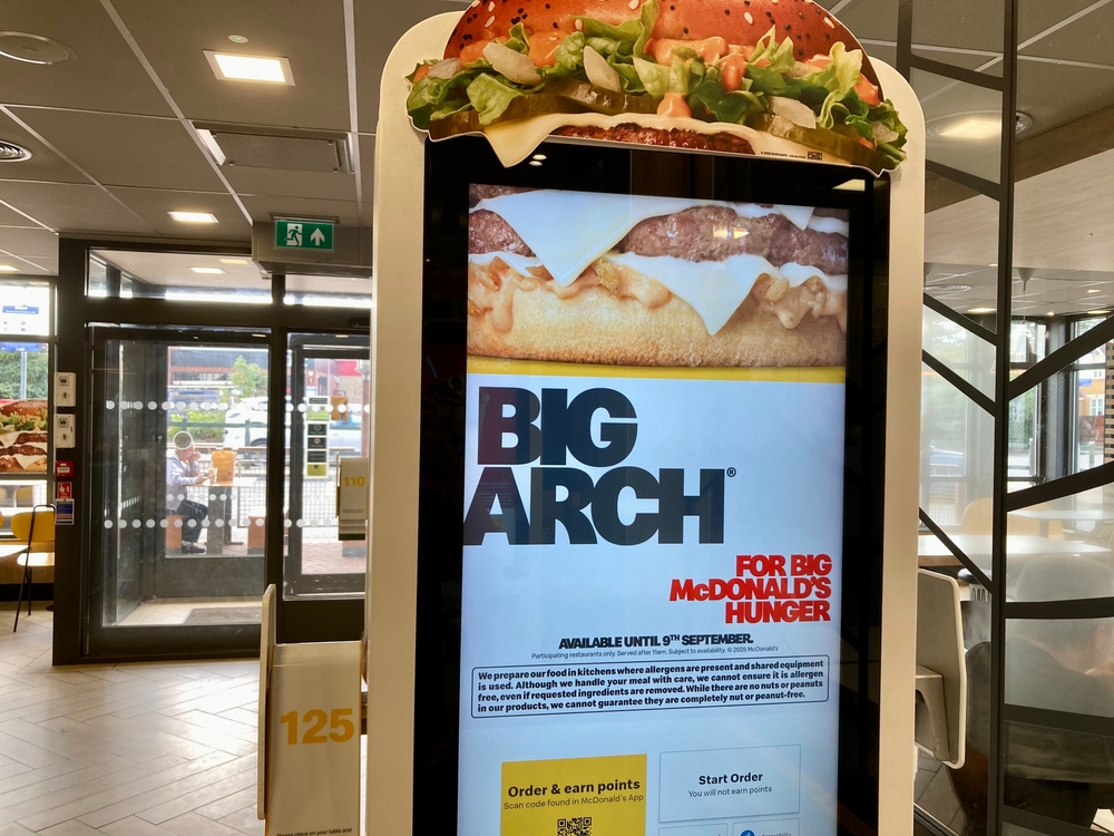 A kiosk screen displaying a promotion of the Big Arch burger inside a McDonald's store.