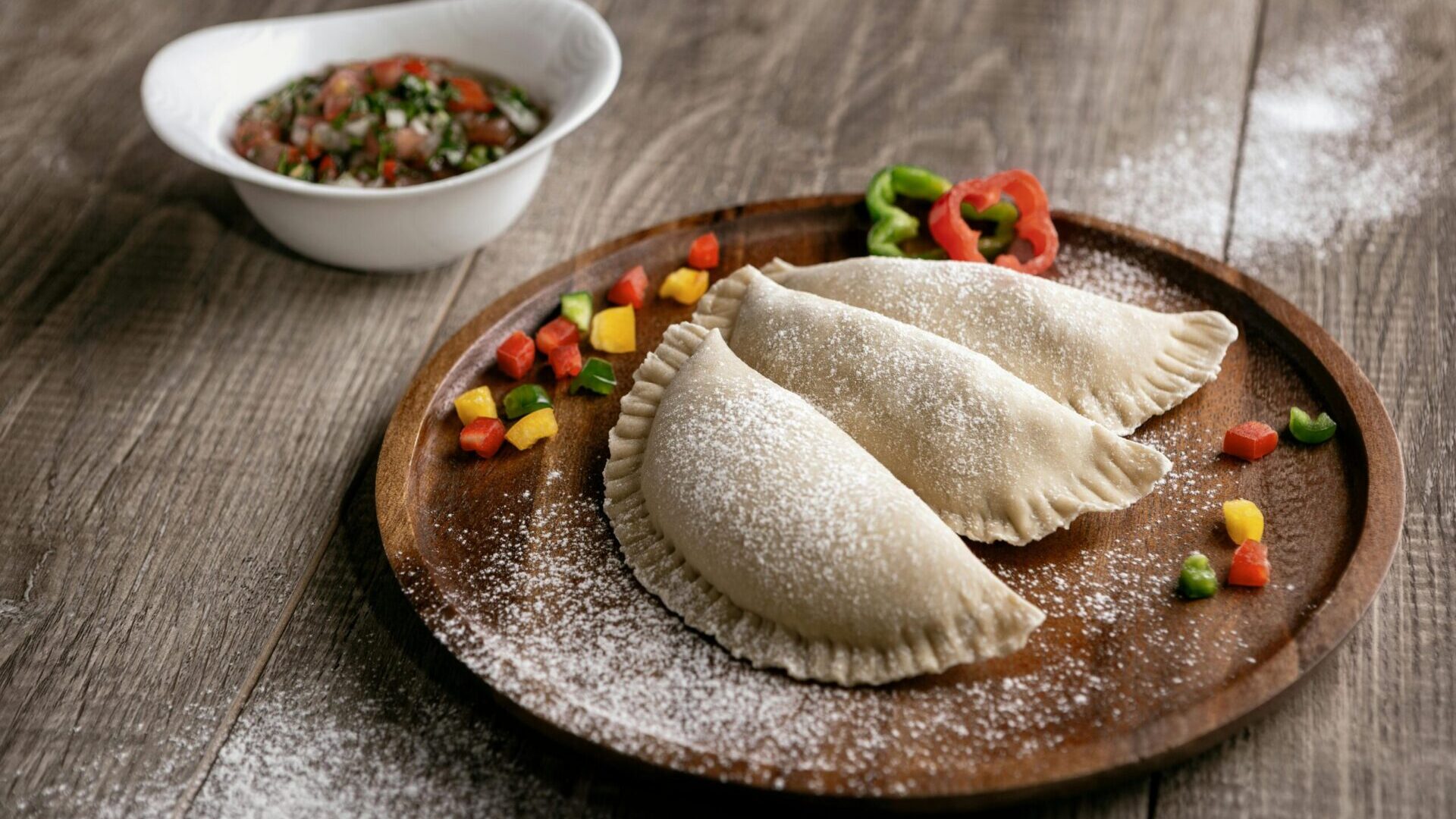 Close-up of empanadas arranged on a plate with golden-brown crust.