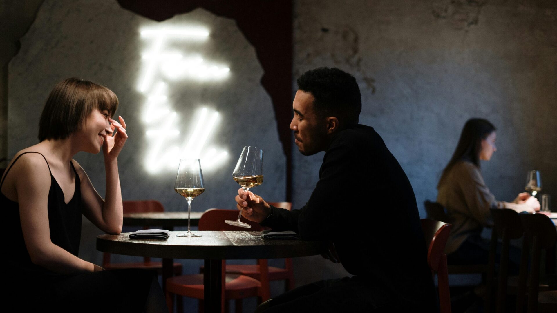 Couple sitting at a restaurant table with drinks during a quiet conversation.